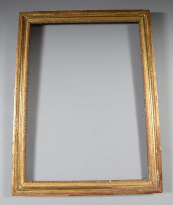 an antique gold frame with a mirror on the wall