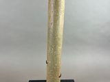sculpture of a tall cylinder on a black base on a white background