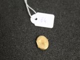 a close up of a coin on a black surface with a price tag