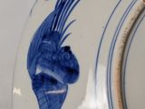 a blue and white plate with a blue fish on it