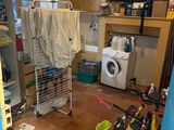 une buanderie équipée d'un lave-linge et d'un vélo