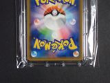 a pokemon card in a plastic case on a table