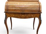 un bureau ancien avec un plateau en bois et des pieds sculptés