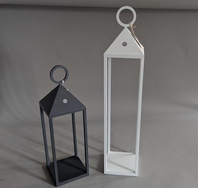 two white lanterns sitting next to each other on a table