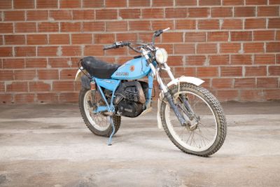 a blue motorcycle parked in front of a brick wall