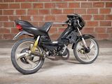 a black motorcycle parked in front of a brick wall