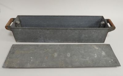 two metal trays with handles and handles on a white surface