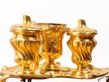 two golden vases sitting on a tray on a table