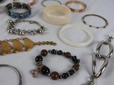 many different types of bracelets and rings on a table