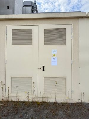 a white building with two doors and a sign on it