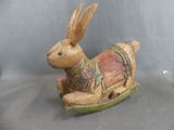 a small wooden toy of a rabbit on a sled
