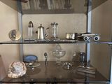 a glass shelf that has a lot of silver items on it