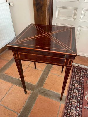 a small table with a wooden top on a tile floor