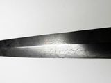 a large black knife that is on a white surface