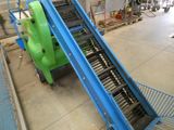 a conveyor belt in a factory with a green machine on it