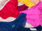 une pile de sous-vêtements posée sur un lit, les uns à côté des autres