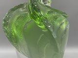 a green glass vase with a leaf design on it