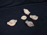 four small pieces of pottery sitting on top of a black cloth
