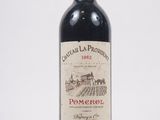 une bouteille de vin rouge posée sur une table blanche
