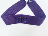 un gros plan sur une ceinture violette ornée de perles