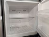 an empty refrigerator with the door open and no food inside
