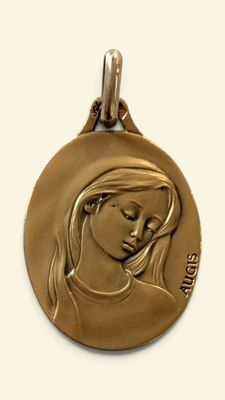 médaille d'or représentant une femme les yeux fermés sur fond blanc