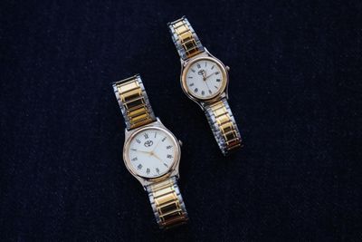 pair of two ladies ' s watches on a black surface