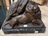 a statue of a lion laying on a marble table