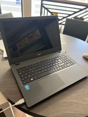 un ordinateur portable posé sur une table, avec une souris dessus