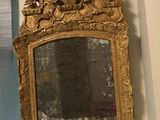 a gold mirror hanging on the wall in a room
