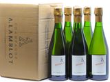 quatre bouteilles de vin sont alignées à côté d'un carton