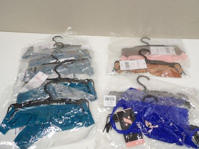 several bags of clothes are wrapped in plastic on a table