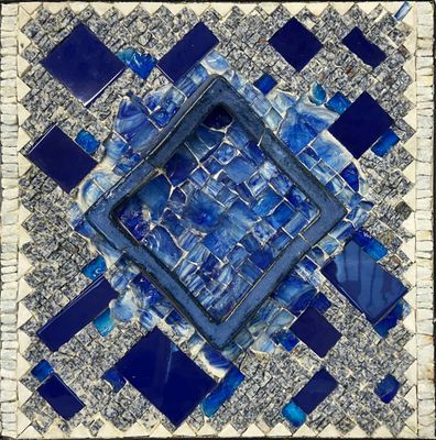 a blue and white mosaic tile with a square hole in the middle
