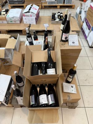 de nombreuses caisses de vin posées par terre dans un magasin