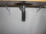 a metal pipe that is attached to a wooden shelf