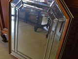 un miroir posé par terre à côté d'une commode