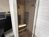 un sauna installé dans un coin d'une pièce équipée d'une télévision