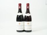 deux bouteilles de vin posées l'une à côté de l'autre sur une surface blanche
