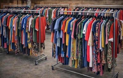 beaucoup de vêtements suspendus à une étagère dans une pièce
