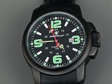 une montre noire avec des chiffres verts, posée sur une table