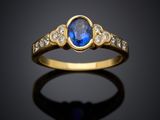 une bague en or avec un saphir bleu et des diamants