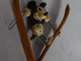 skier mickey mouse figurine hanging on a wall with skis