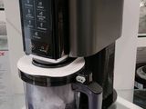 une cafetière posée sur une étagère en verre dans un magasin
