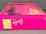a pink box with a doll in it on a table