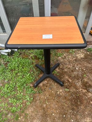 une petite table sur laquelle est posée une étiquette, devant une porte vitrée
