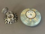 a small silver object and a small silver object on a table