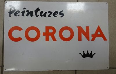 une affiche accrochée au mur sur laquelle on peut lire « corona », avec une couronne à côté