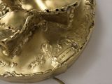 a gold plate with a flower on it on a table