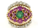 a close up of a ring with a green and purple stone surrounded by diamonds