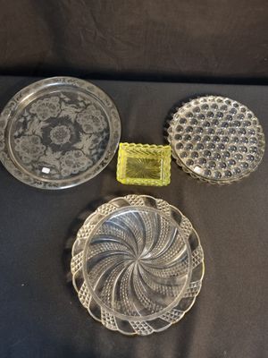 trois assiettes en verre et un récipient en verre posés sur une table
